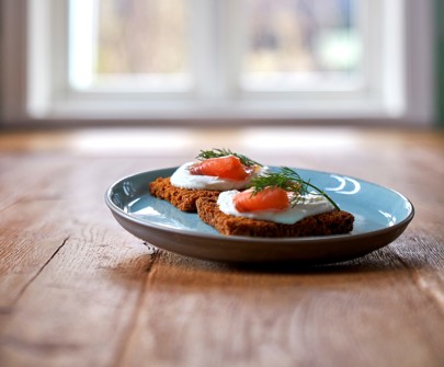 Two slices of bread, topped with salmon, Arla Skyr and thyme dressing
