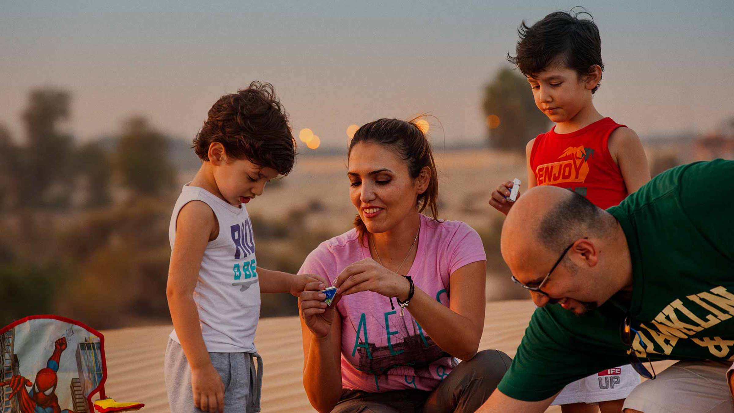 A family eating Arla cheese triangles in a desert