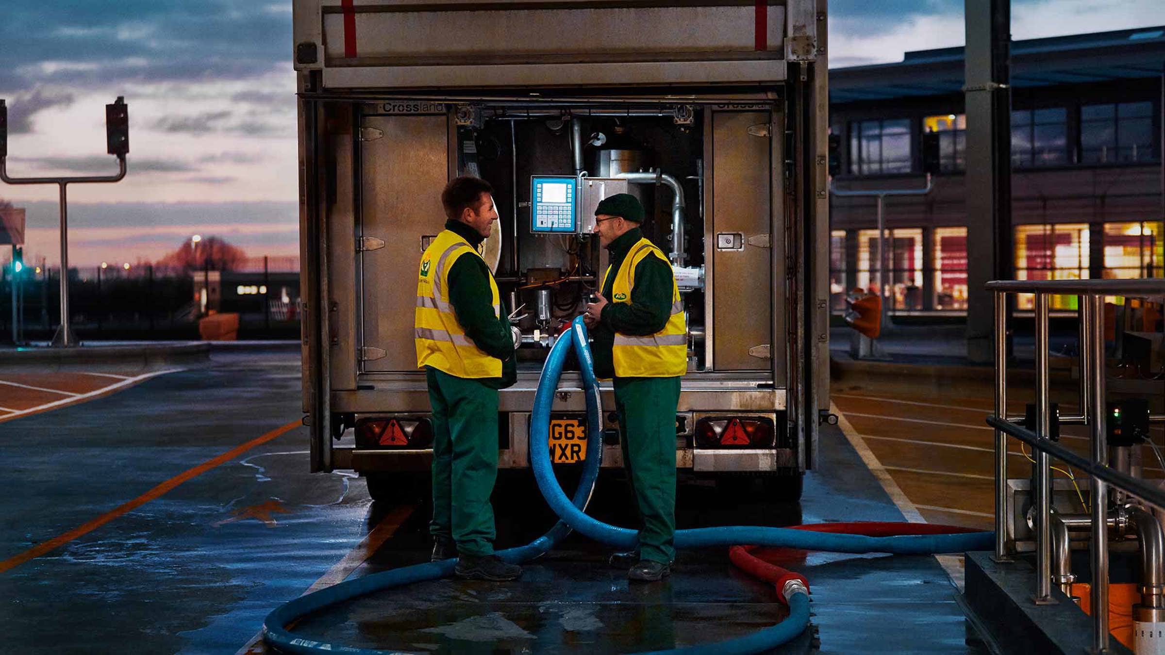 Two Arla staff talking behind a truck