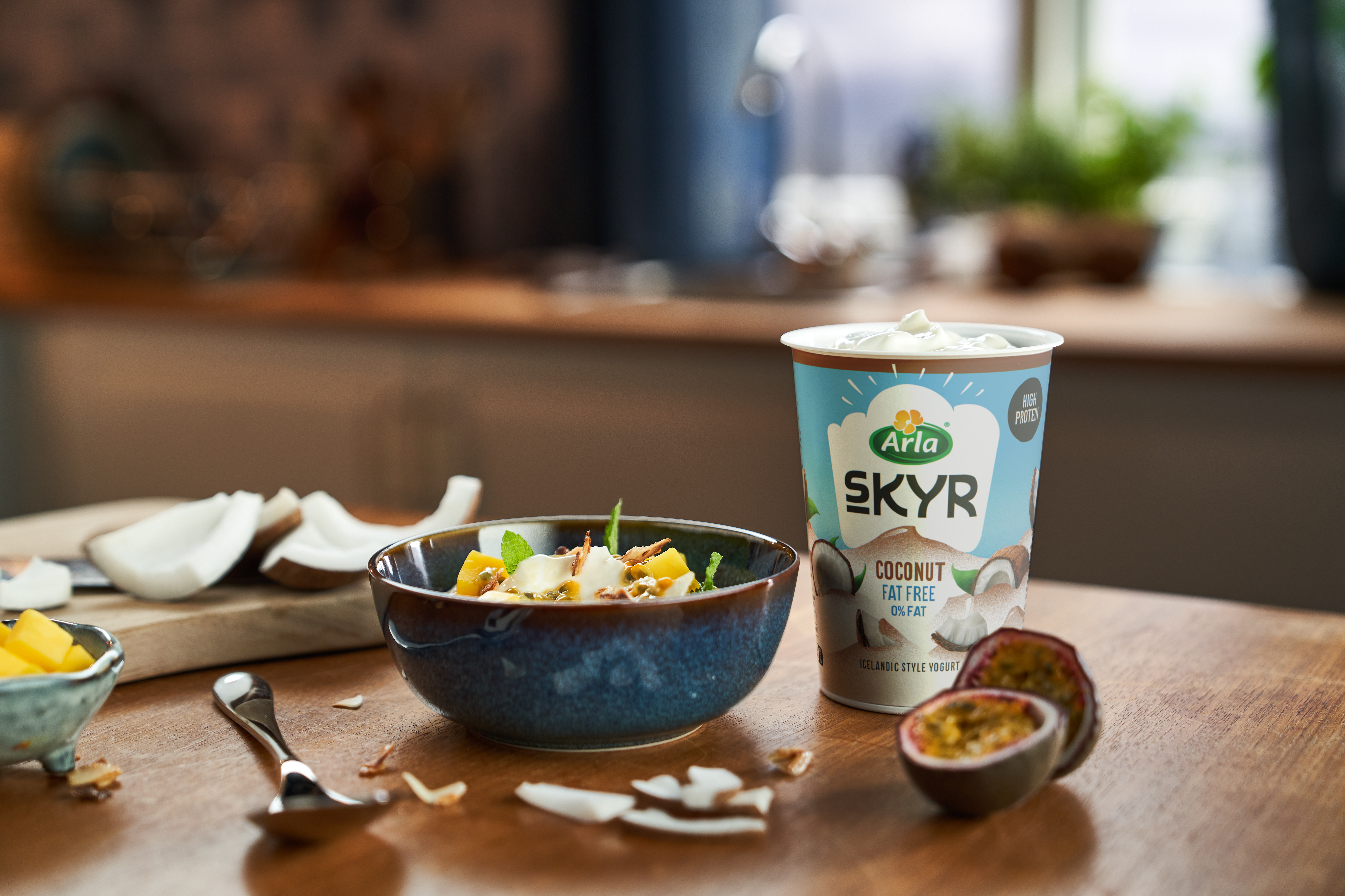 Pot of Arla Creamy Skyr with a bowl of Skyr and fruit.