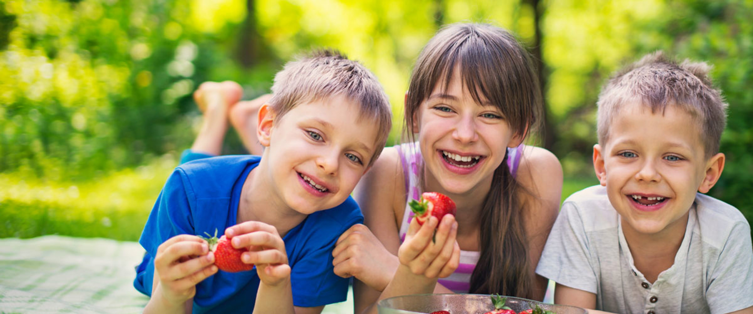 3 Children eating strawberries