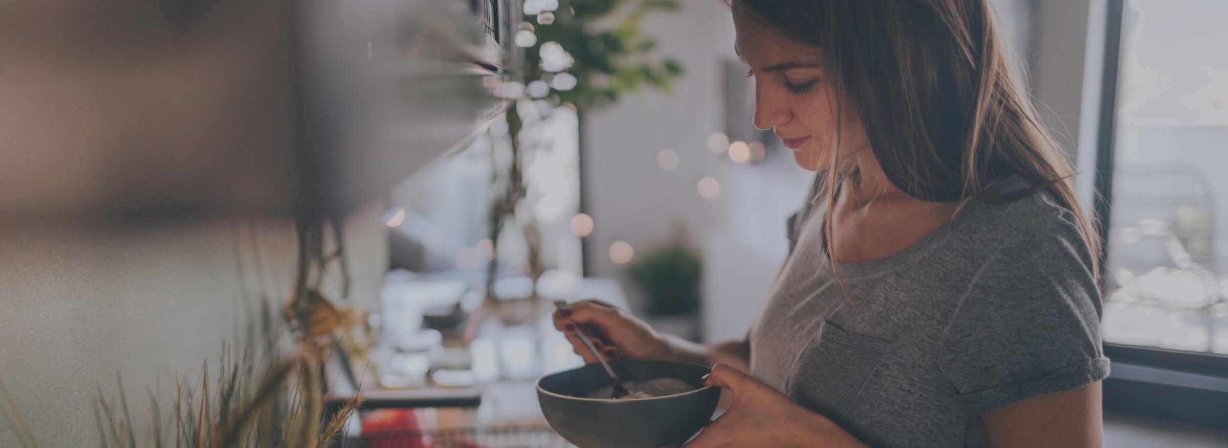 Woman eating muesli in a kitchen