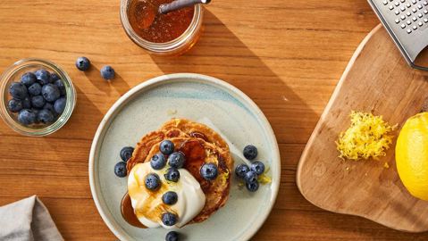 Stack of pancakes with dollop of Skyr Nordic Cherry on top, and a sprinkling of brown sugar