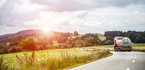 Arla lorry driving on the road, with picturesque sunset