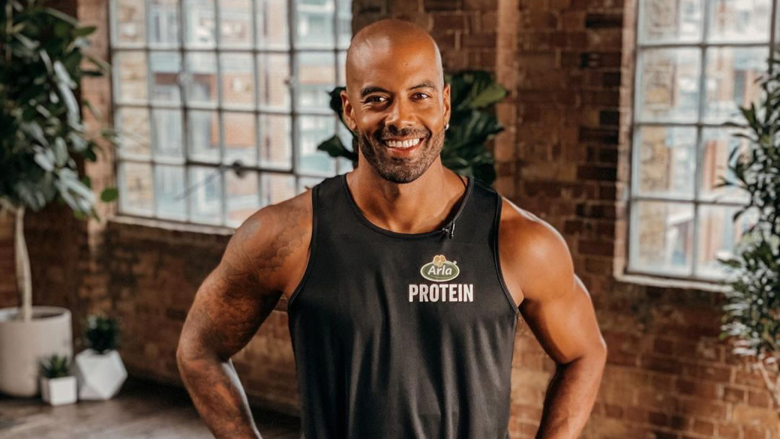 Louis Rennock smiling in the stuido wearing an Arla Protein vest top