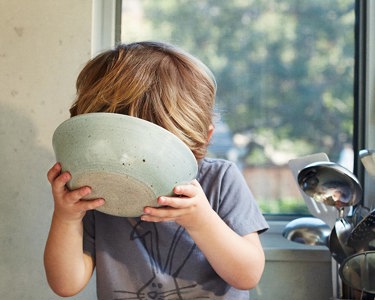 Child drinking milk from a bowl