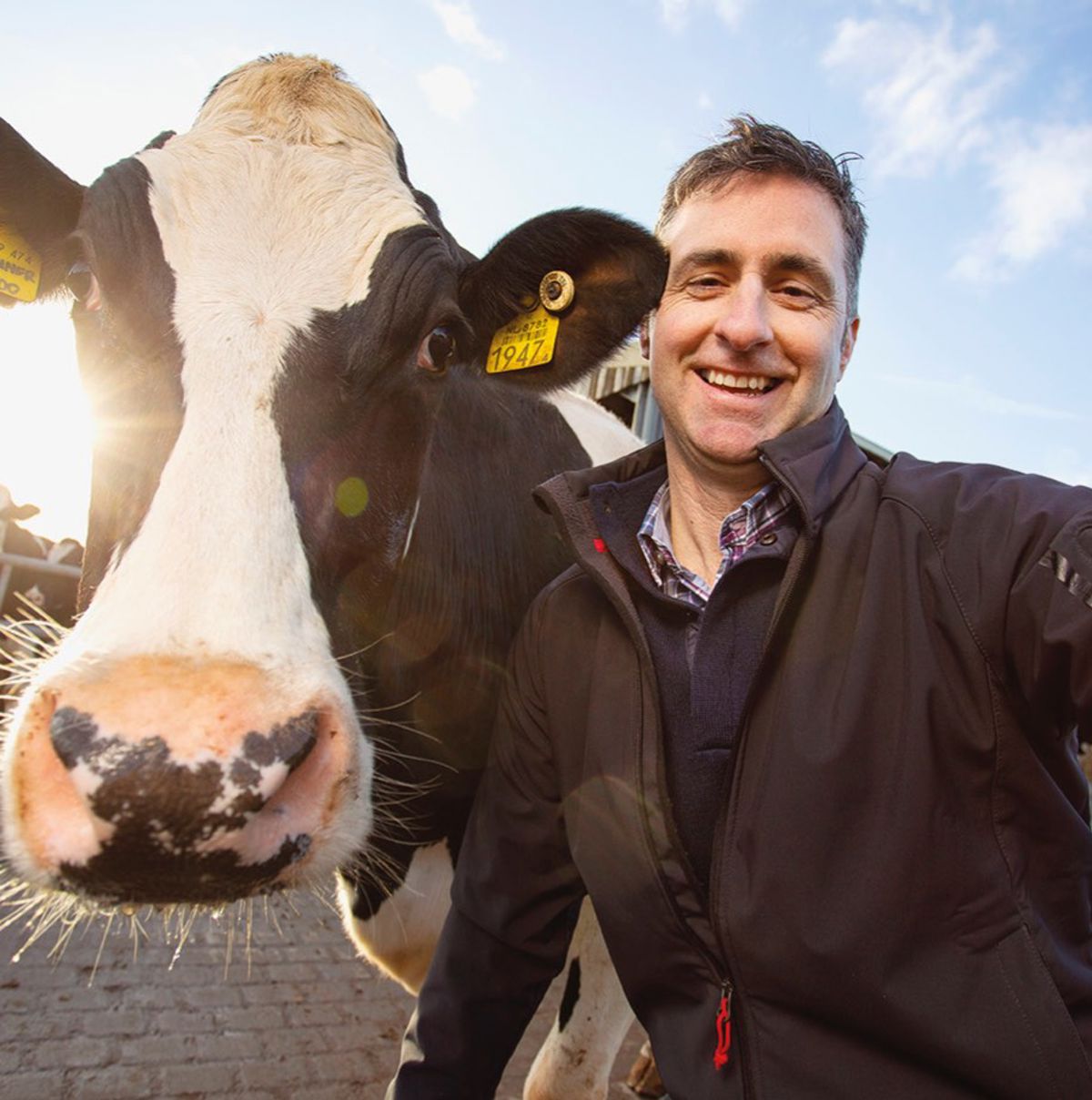 Farmer standing with his cow