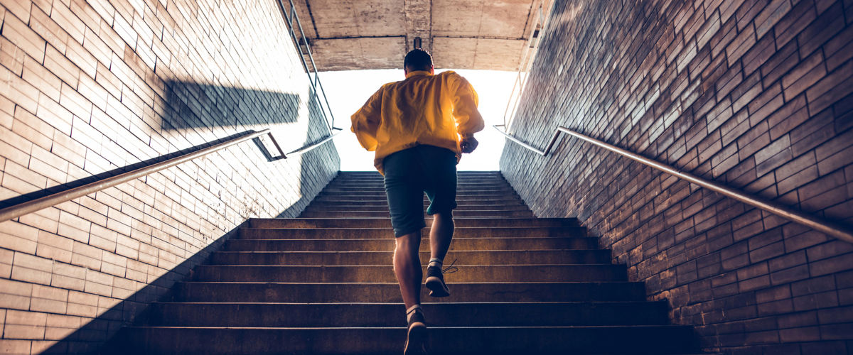 man running up stairs outside