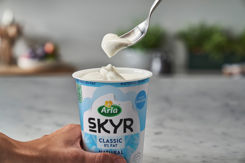 Arla Skyr pot with a spoonful being lifted