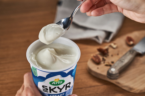 Arla Skyr pot with a spoonful being lifted