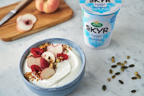 Arla Skyr pot with a spoonful being lifted