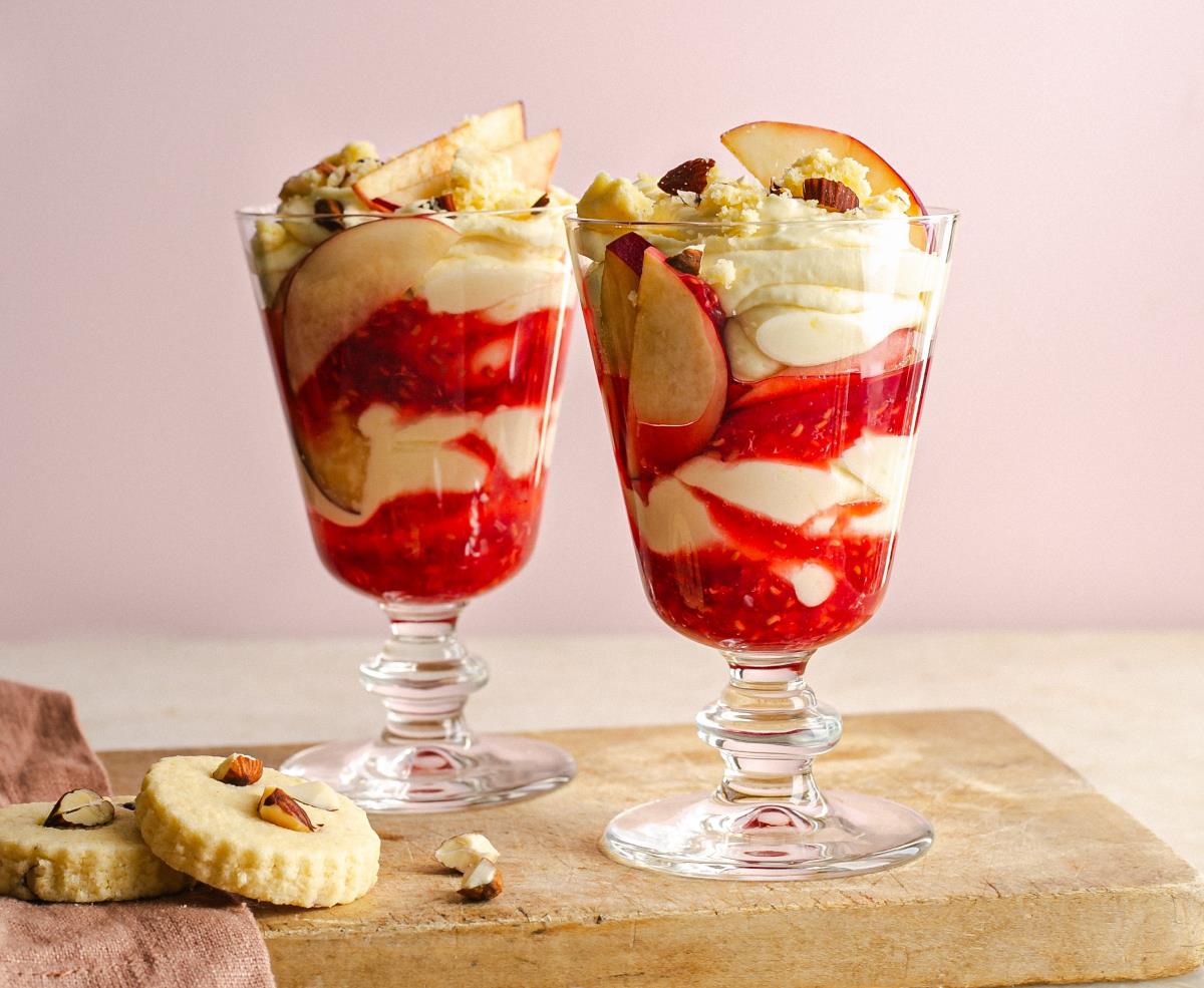 Two Lactofree Peach Melba fool desserts laid out on a wooden serving block