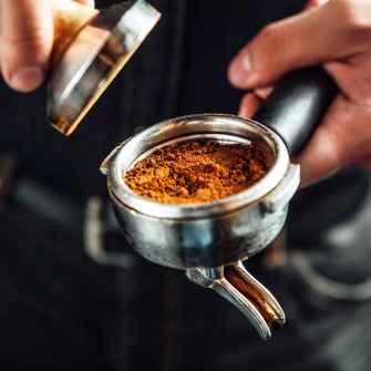 Coffee grounds being packed into a filter holder