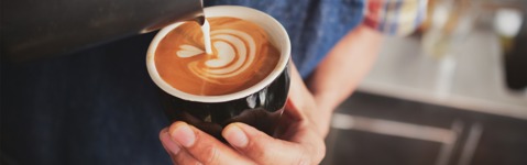 Milk being poured into a cup of coffee