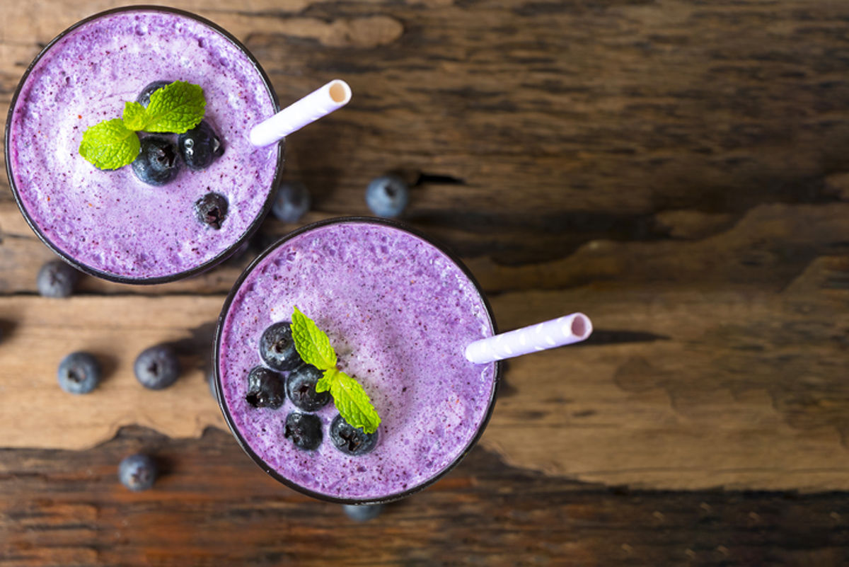 Two glasses of berry smoothie topped with blueberries
