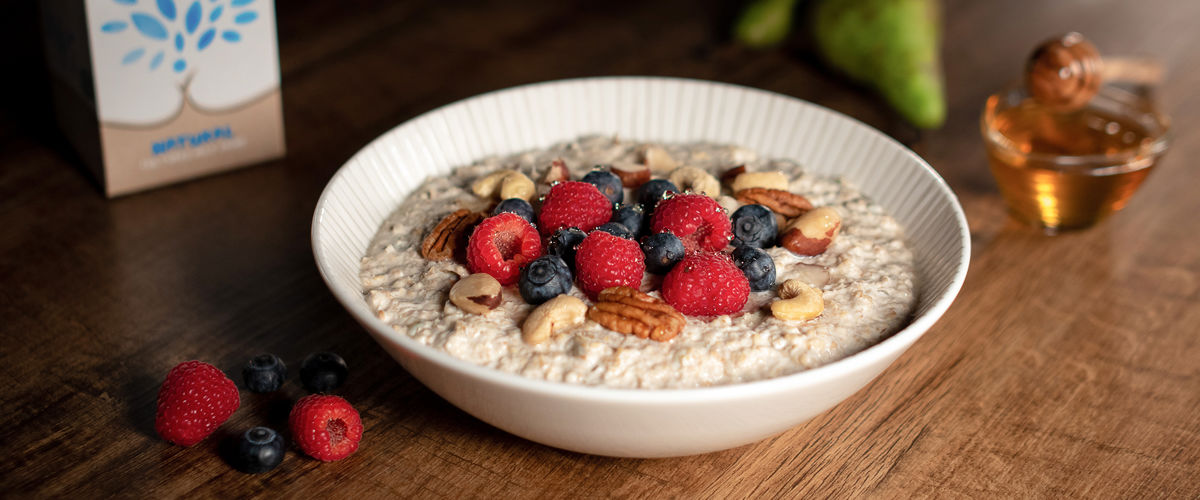 A bowl of muesli topped with berries and nuts