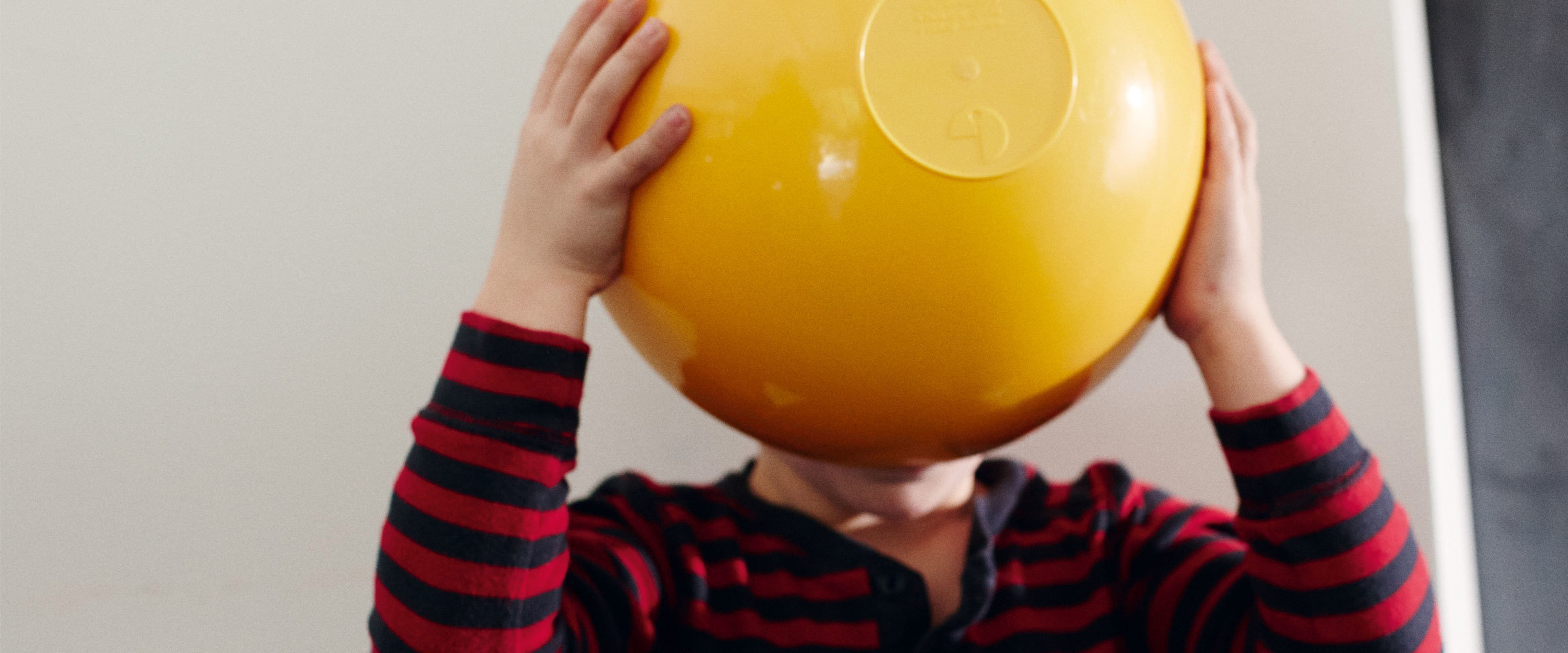 A child holding a bowl over their face