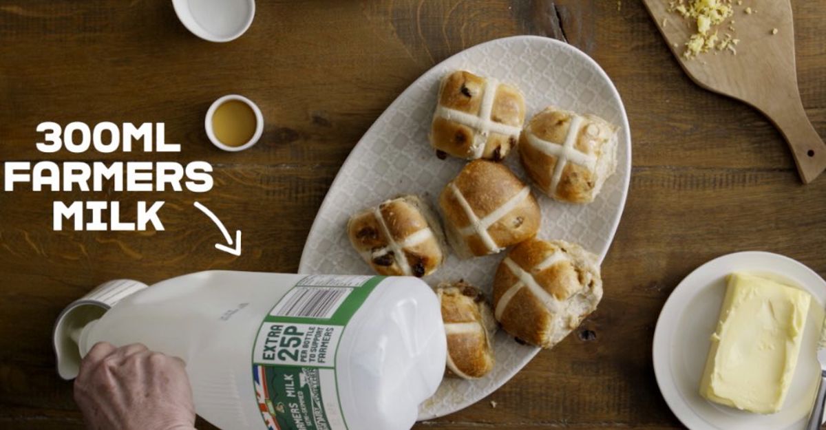 Hot Cross Buns next to a hand pouring farmers milk into a jug. 300ml Farmers Milk