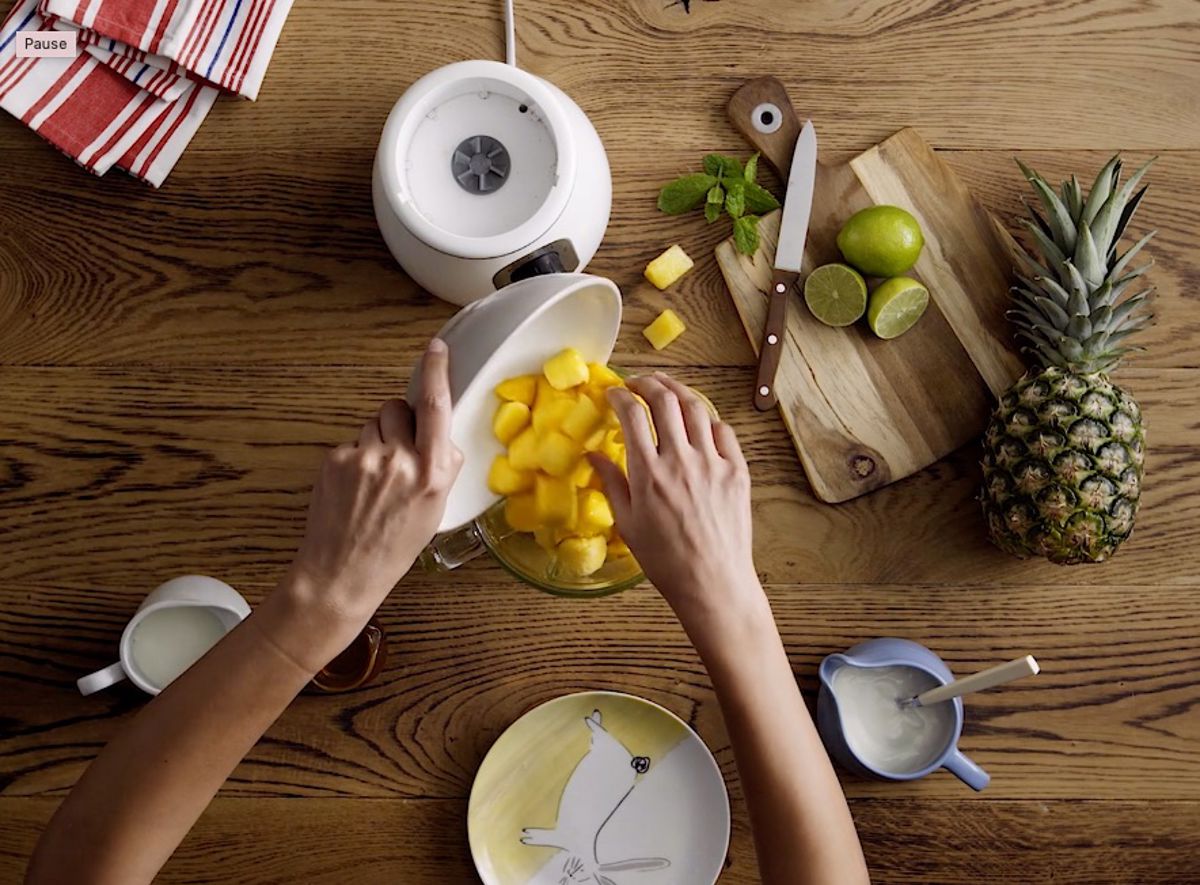 Diced pineapples being poured into a blender