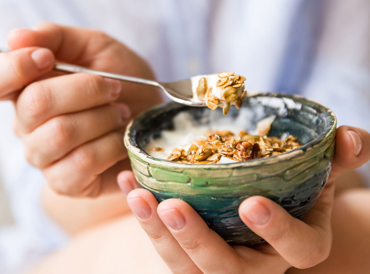 Yogurt and muesli spooned out of a bowl