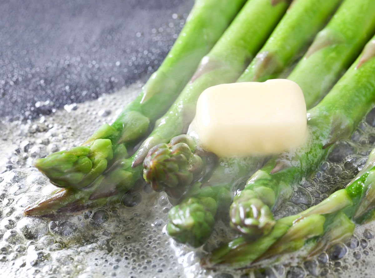 Butter melting onto cooking asparagus
