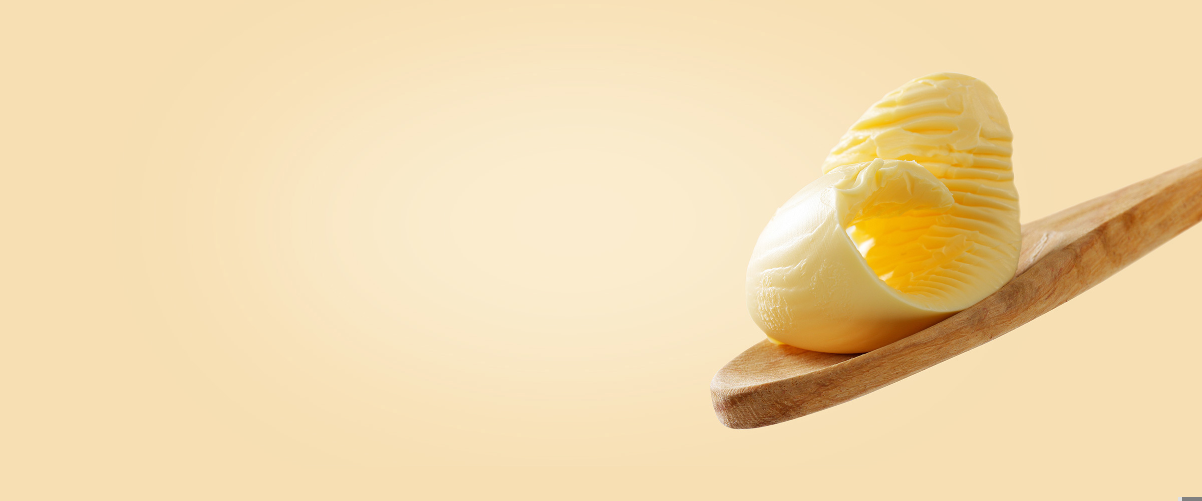 A curl of butter on a wooden spoon