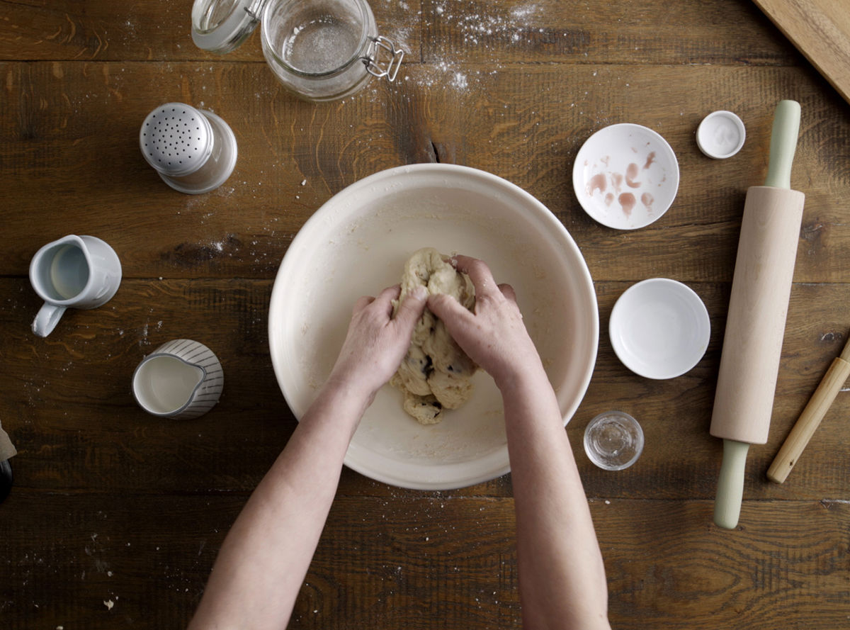 A pair of hands kneading dough