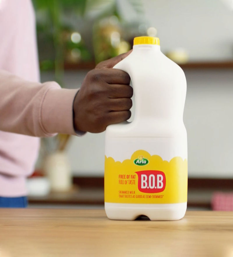 A man clutching a bottle of Arla BOB milk