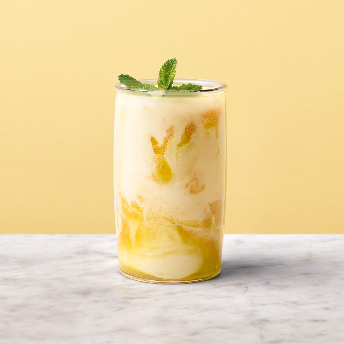 A smoothie in a glass topped with mint