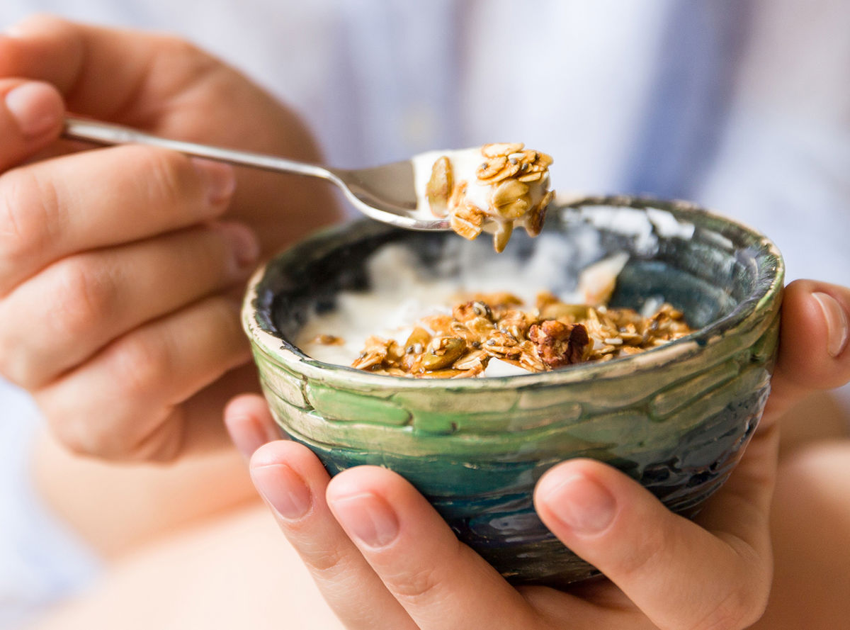 Yogurt and muesli spooned out of a bowl
