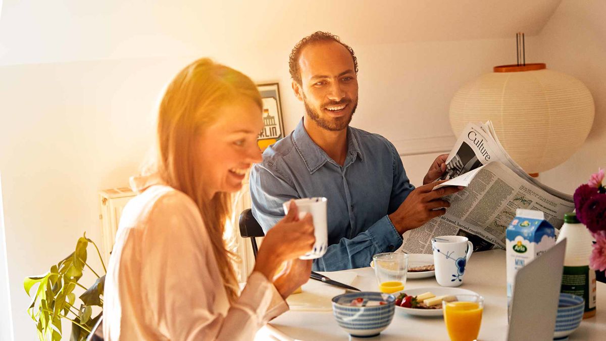 A couple smiling over breakfast