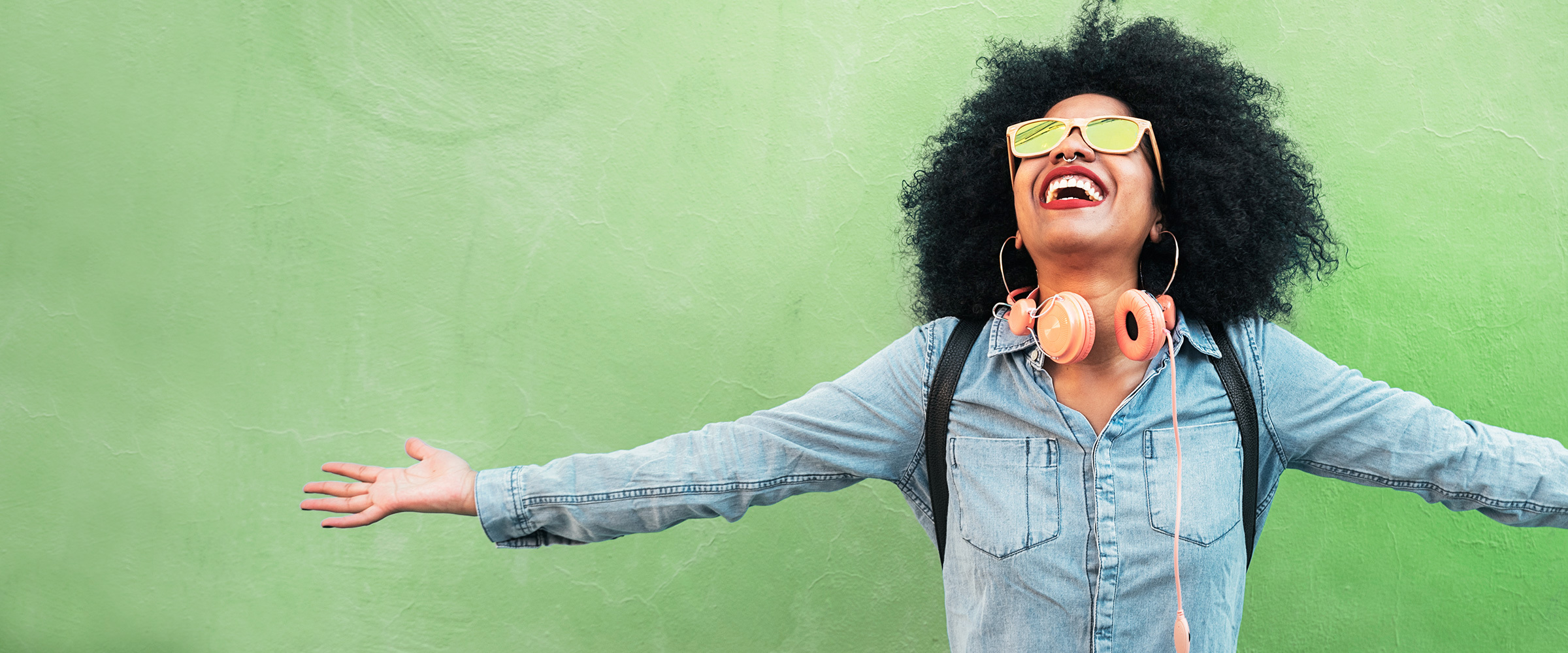 A woman smiling with outstretched arms