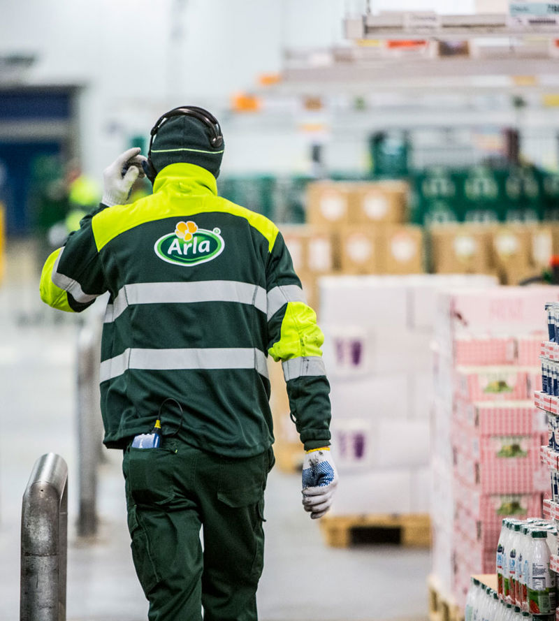 An Arla employee walking through a warehouse