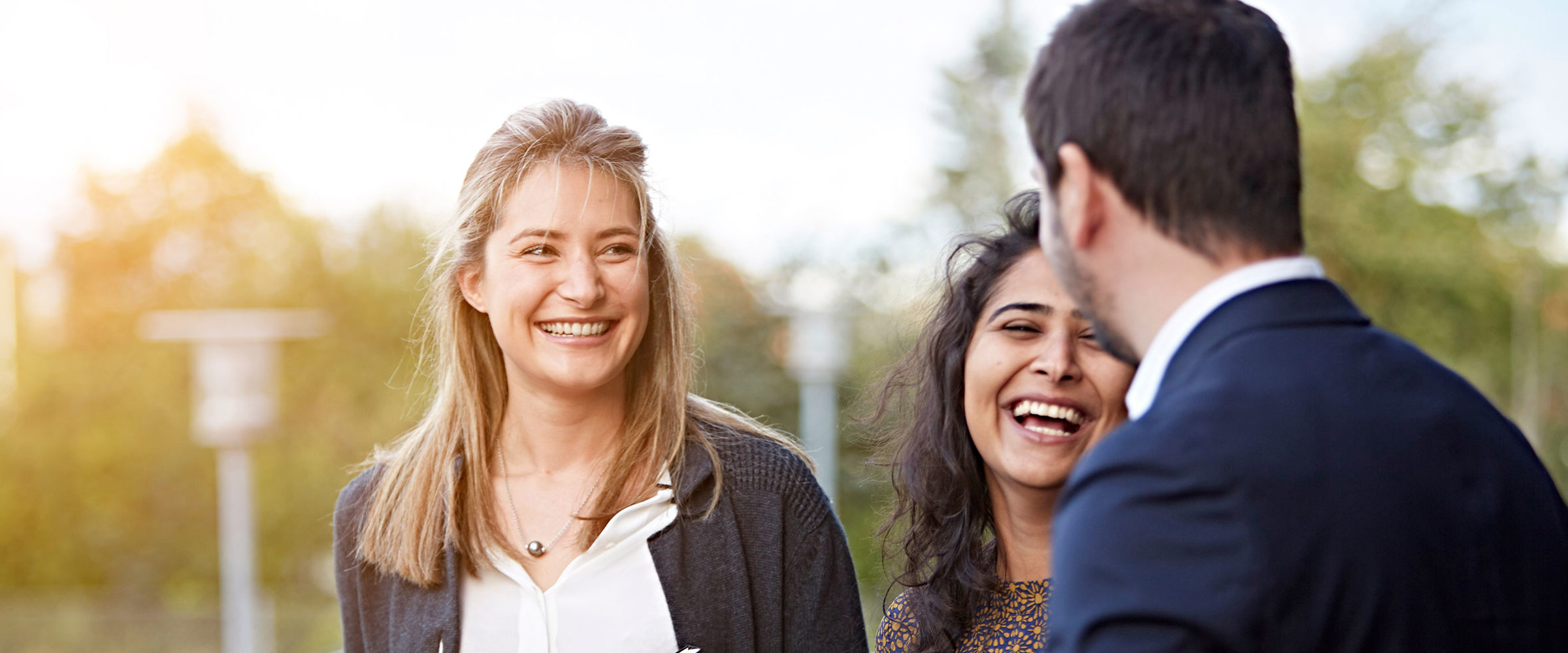 3 people laughing and talking outside