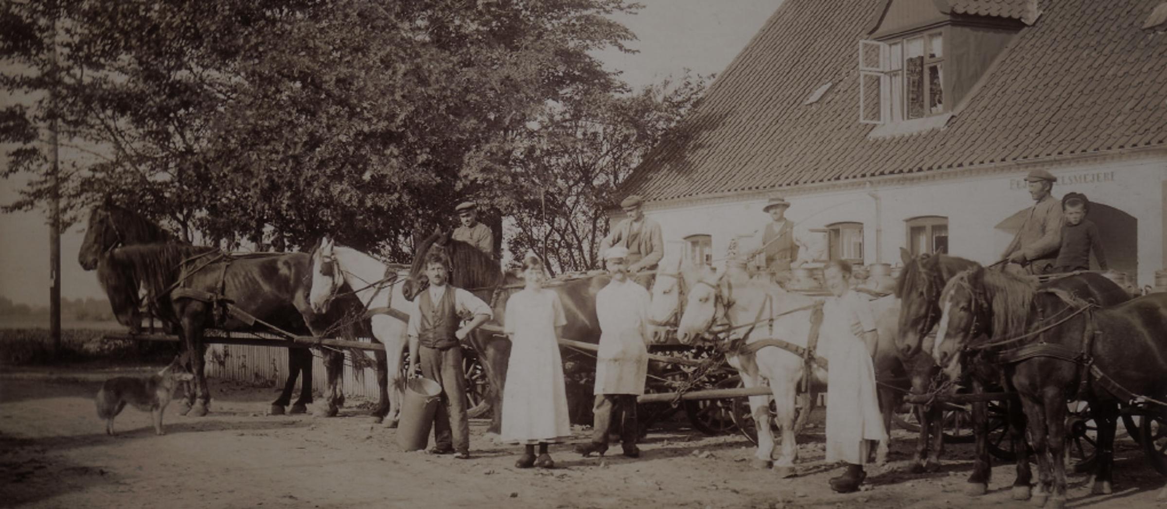 Old black and white image of farmers and horses with carriages