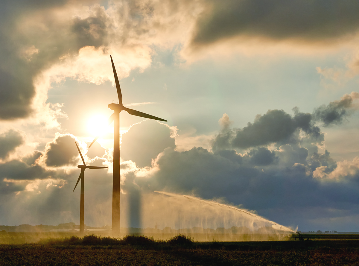 Wind turbines in front of the sun on a cloudy day