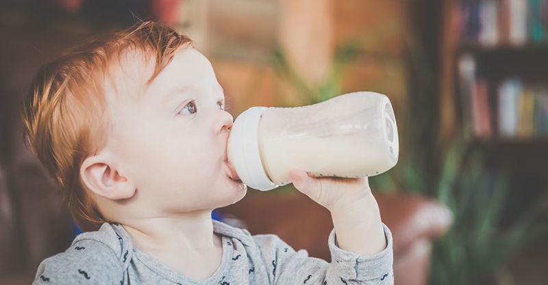 Toddler drinking milk from a sippy cup