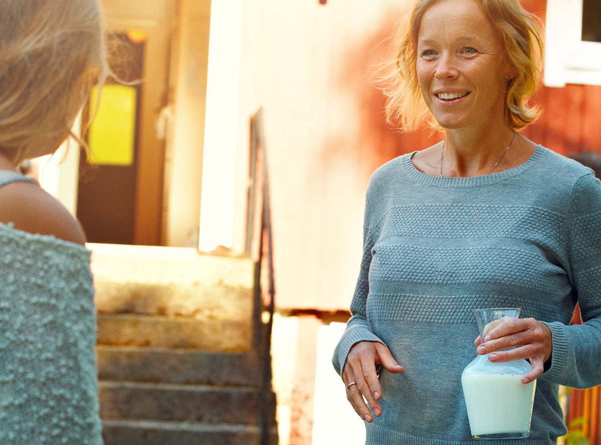 Woman holding a jug of milk outside