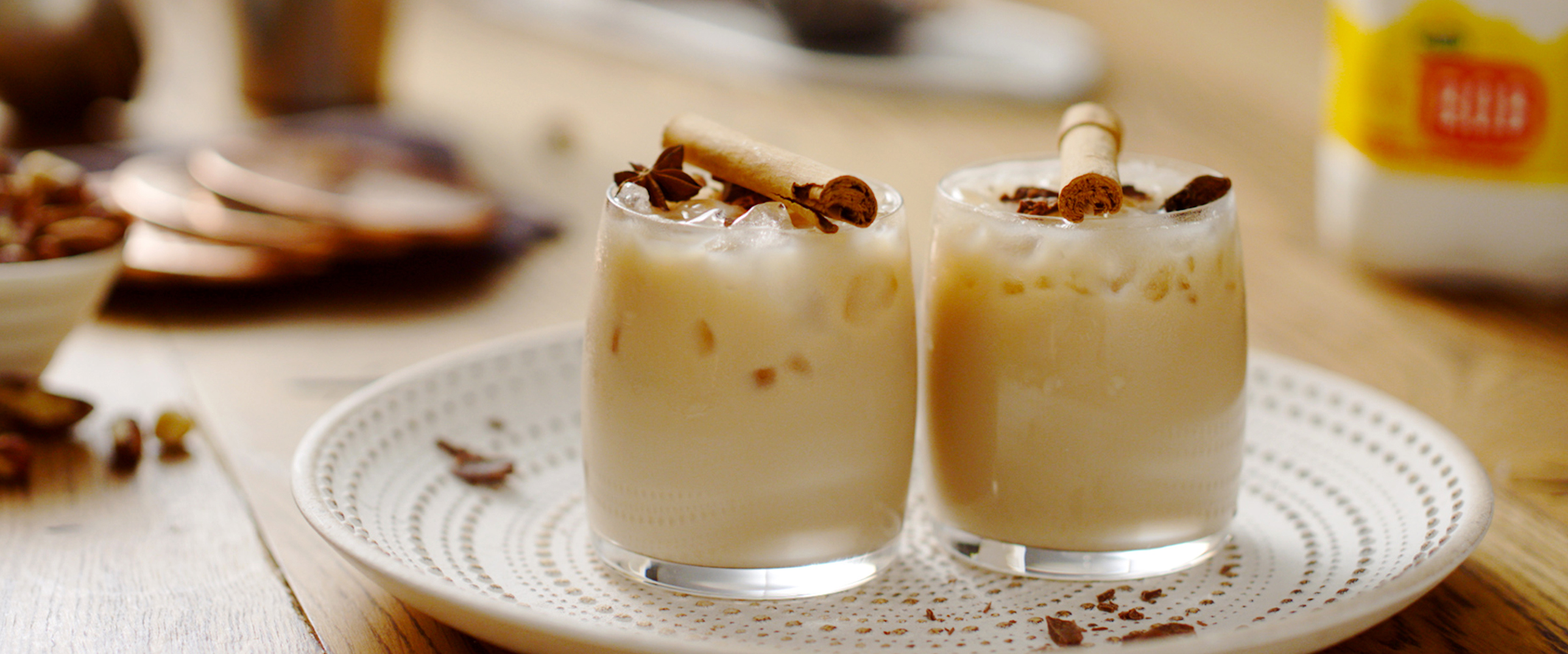 Two glasses of white russian topped with cinnamon sticks