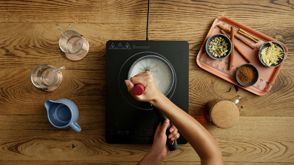 Boiling milk being whisked in a pot