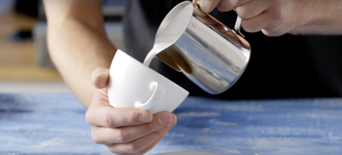 Frothy milk being pured into a cup