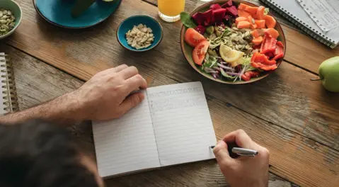 Hands writing in a notebook