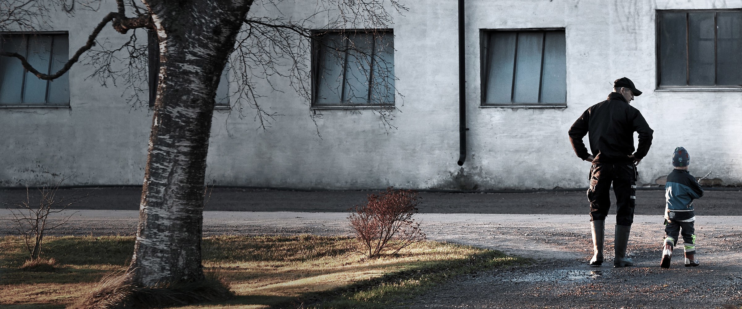 A farmer and his child outside a farm building